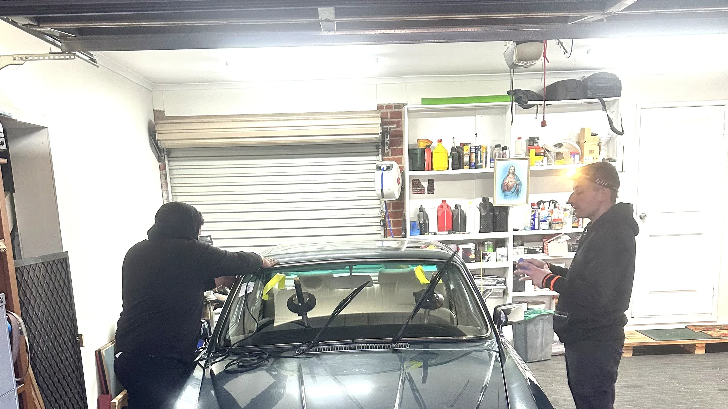 Technicians fitting a replacement windscreen to a vehicle