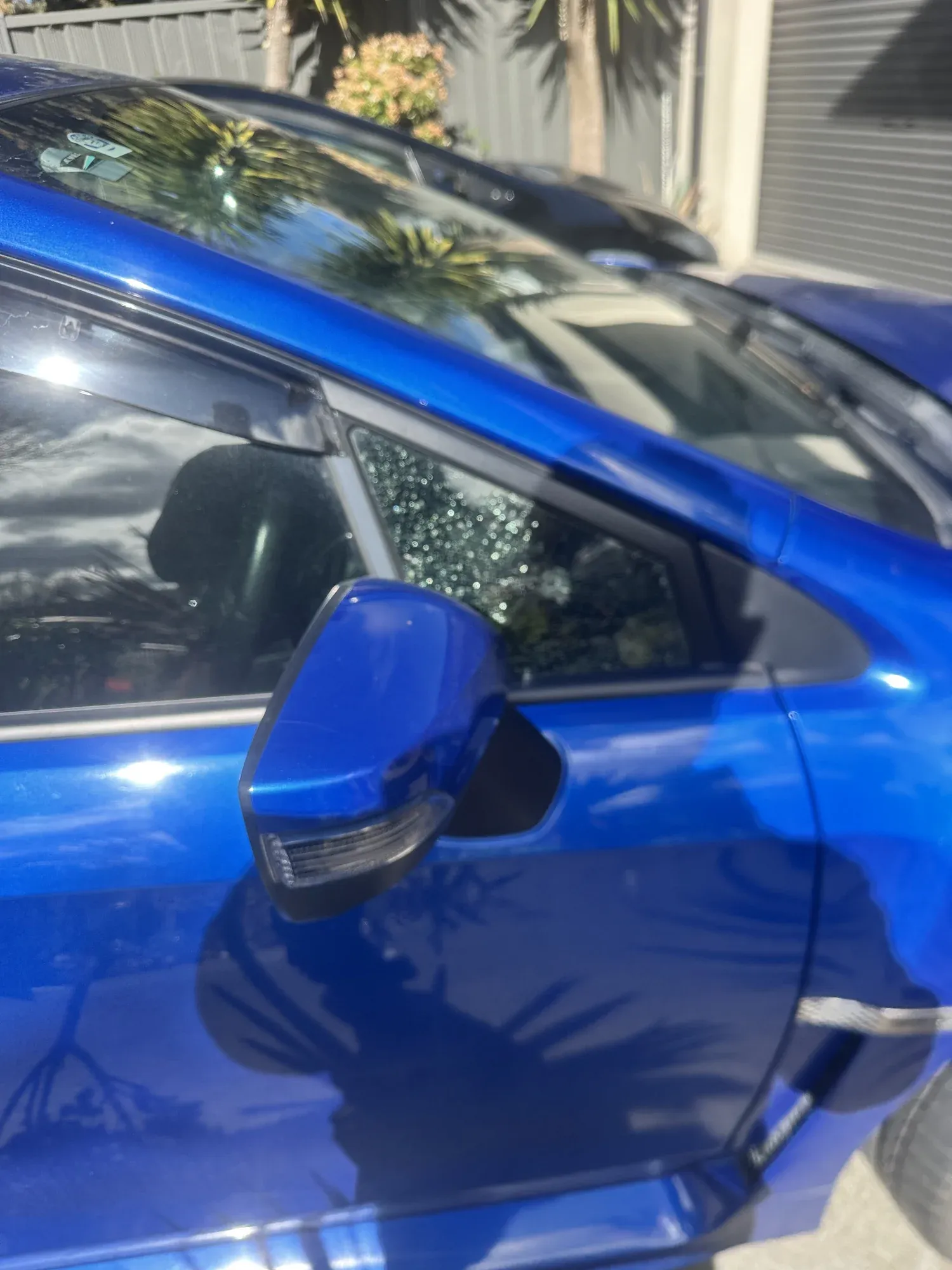 Front door glass and mirror on a blue hatchback