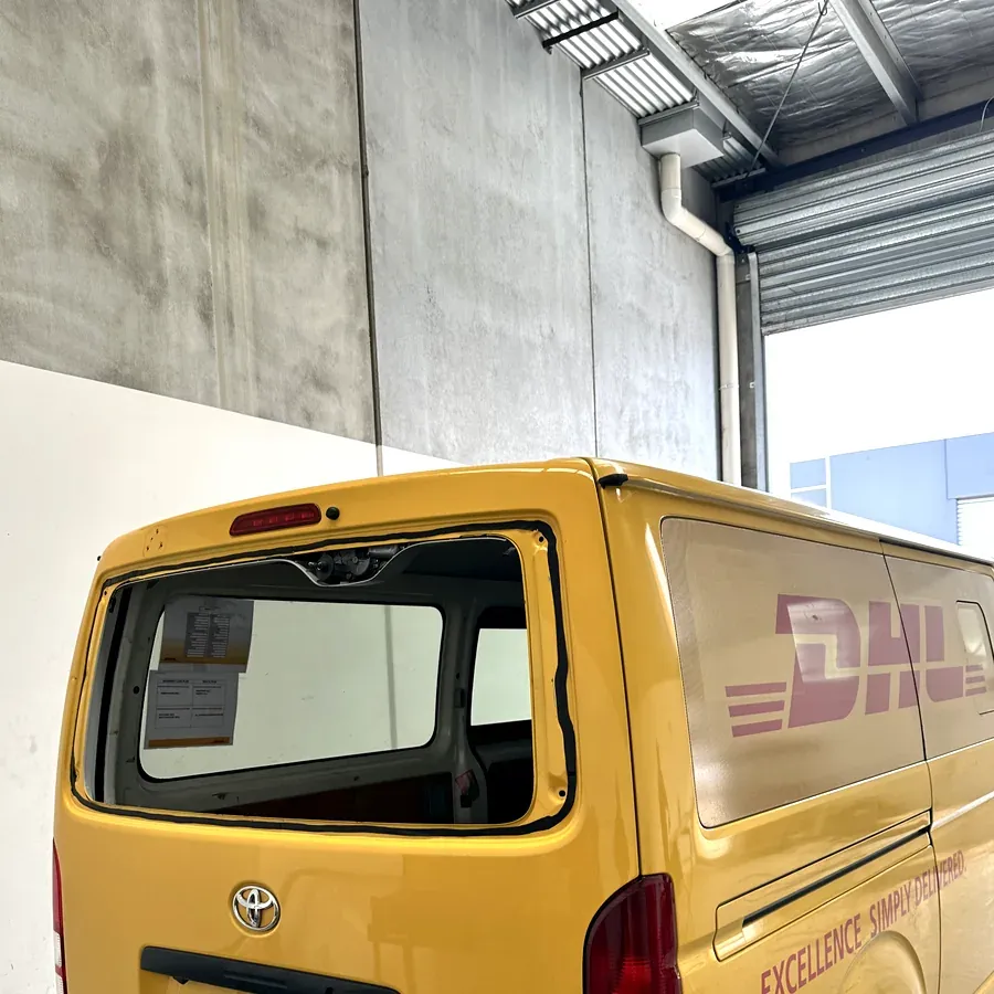 Rear glass replacement on a yellow commercial delivery van