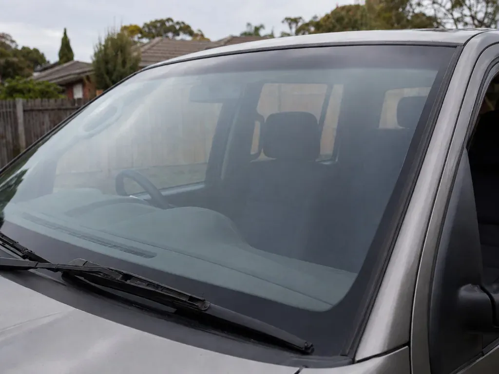 After: silver car with a newly fitted clear front windscreen after replacement