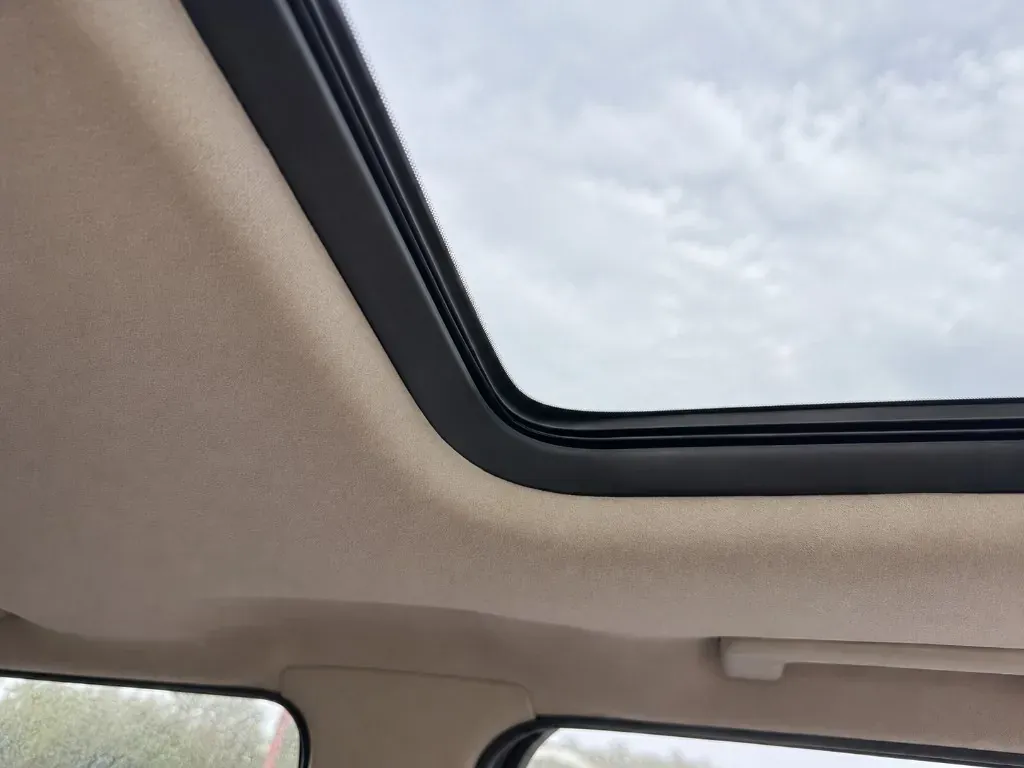 After: interior view of a clean sunroof opening with a sound seal and clear headlining